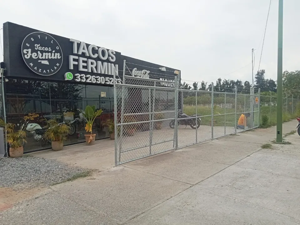 Alambrado con puertas abatibles frente a un restaurante