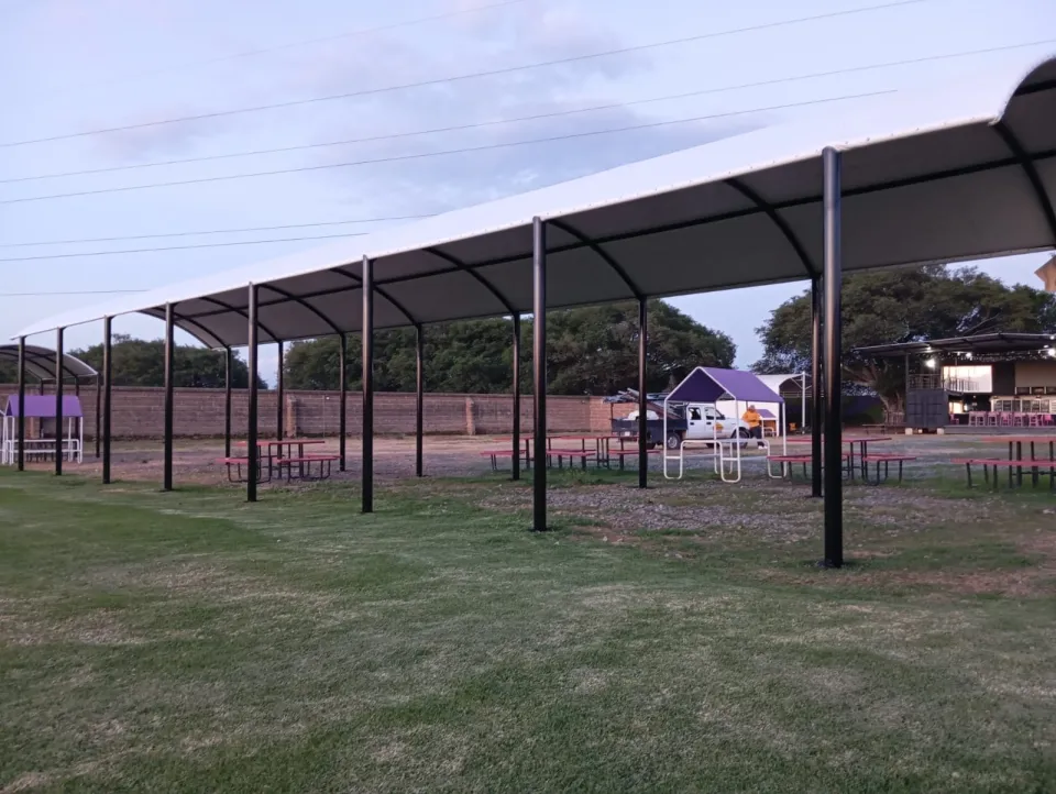 Techado de lona tensada sobre un patio con jardín