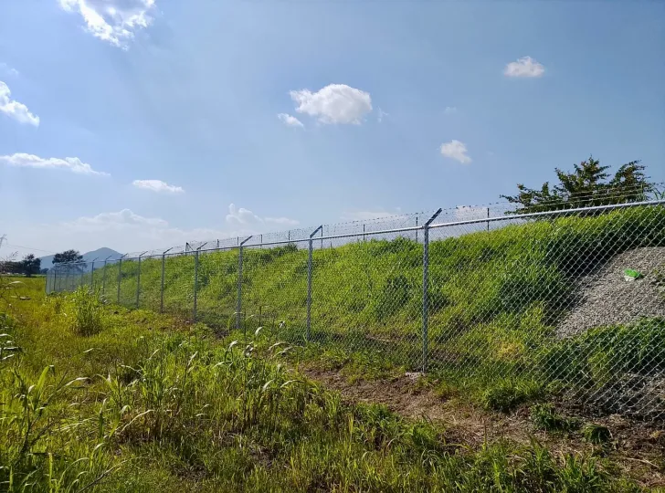 Cerca de malla ciclónica delimitando un terreno en el campo